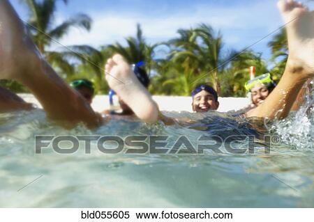 Stock Photography - Hispanic family playing in water. Fotosearch