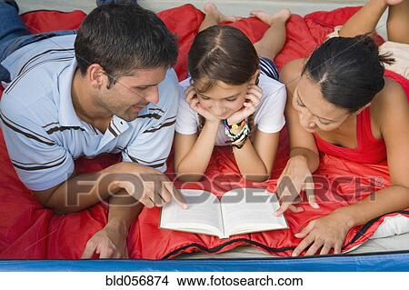 Picture - Hispanic family reading. Fotosearch