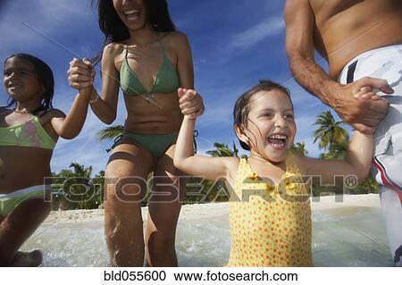 Hispanic family running into water View Large Photo Image Stock Image - Hispanic family running into water. Fotosearch
