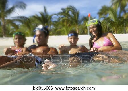 Stock Photograph - Hispanic family sitting in water. Fotosearch