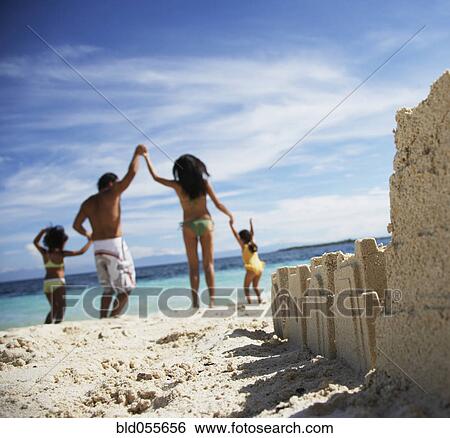 Stock Photograph - Hispanic family with sand castle in foreground. Fotosearch