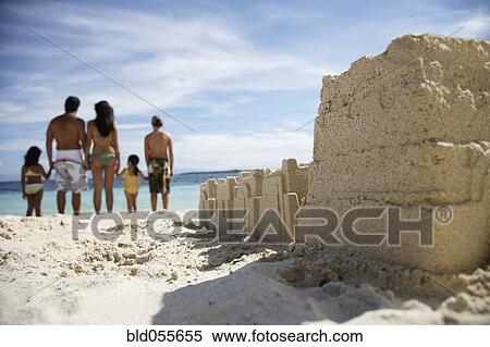 Stock Photography - Hispanic family with sand castle in foreground. Fotosearch
