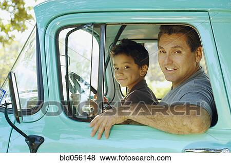 Stock Photo - Hispanic father and son sitting in truck. Fotosearch