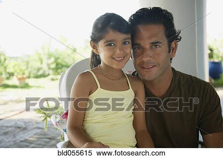 Stock Photography - Hispanic father hugging daughter. Fotosearch