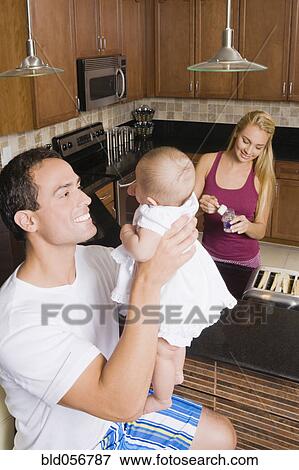 Stock Photo - Hispanic father smiling at baby. Fotosearch