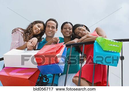 Hispanic friends holding shopping bags View Large Photo Image Stock Photo - Hispanic friends holding shopping bags. Fotosearch