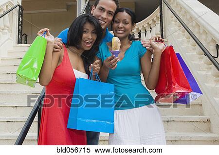 Hispanic friends holding shopping bags View Large Photo Image Stock Photography - Hispanic friends holding shopping bags. Fotosearch
