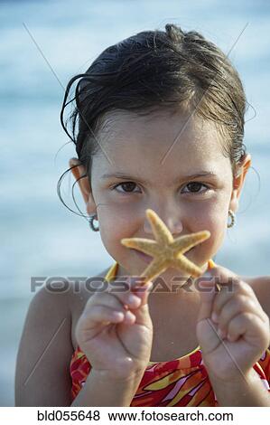 Stock Photo - Hispanic girl holding starfish. Fotosearch