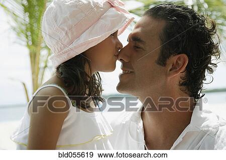Stock Photo - Hispanic girl kissing father on nose. Fotosearch