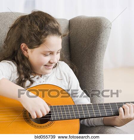 Stock Photo - Hispanic girl playing guitar. Fotosearch