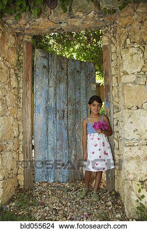Hispanic girl standing in garden doorway View Large Photo Image Picture - Hispanic girl standing in garden doorway. Fotosearch