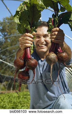 Stock Image - Hispanic man holding organic produce. Fotosearch