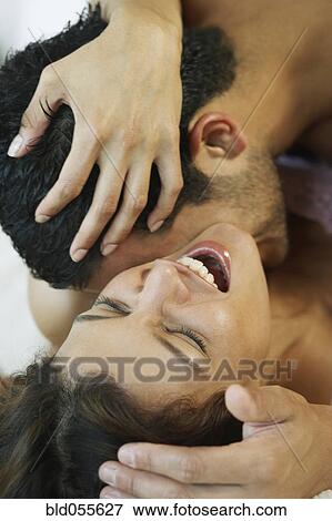 Stock Photo - Hispanic man kissing wife’s neck. Fotosearch