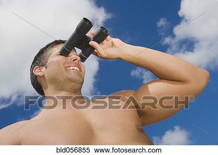 Stock Photography - Hispanic man looking through binoculars. Fotosearch
