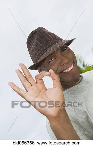 Stock Photograph - Hispanic man making ok hand gesture. Fotosearch