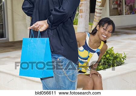 Hispanic man surprising girlfriend with gift View Large Photo Image Stock Image - Hispanic man surprising girlfriend with gift. Fotosearch