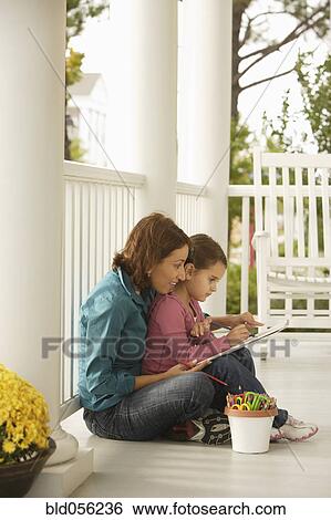 Stock Photograph - Hispanic mother and daughter coloring. Fotosearch