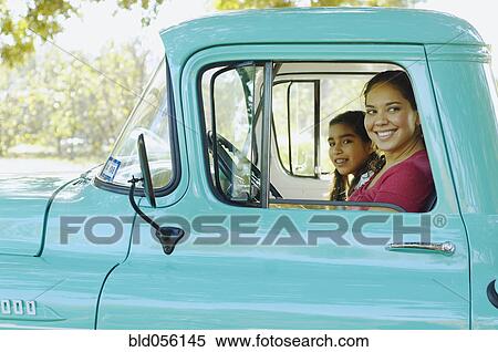 Stock Photography - Hispanic mother and daughter driving truck. Fotosearch