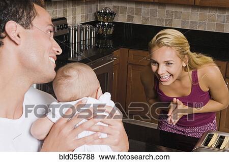 Stock Photo - Hispanic mother smiling at baby. Fotosearch