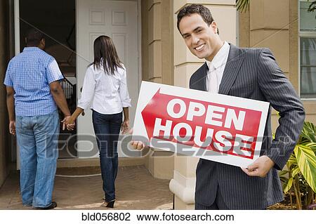 Hispanic real estate agent holding Open House sign View Large Photo Image Stock Image - Hispanic real estate agent holding Open House sign. Fotosearch