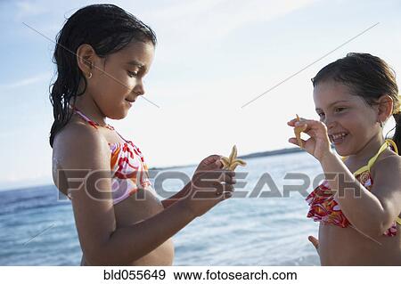 Hispanic sisters holding starfish View Large Photo Image Stock Photo - Hispanic sisters holding starfish. Fotosearch