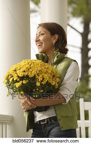 Hispanic woman carrying potted plant View Large Photo Image Stock Photo - Hispanic woman carrying potted plant. Fotosearch