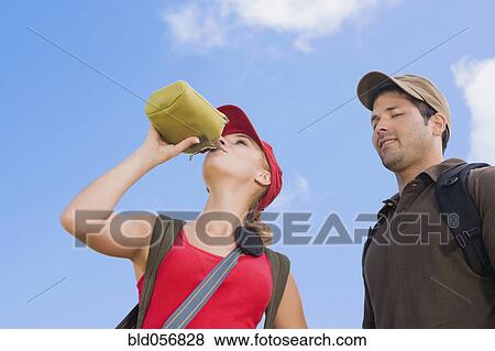 Stock Photo - Hispanic woman drinking from canteen. Fotosearch