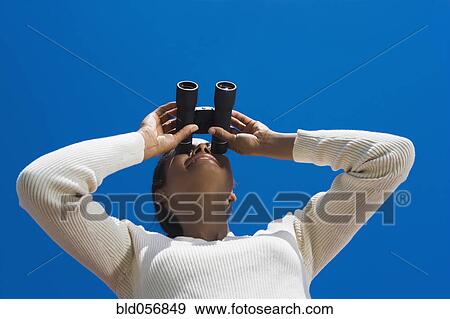Stock Photo - Hispanic woman looking through binoculars. Fotosearch