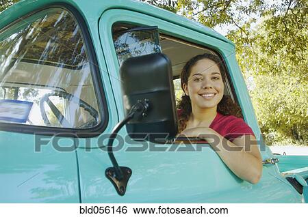 Stock Photograph - Hispanic woman sitting in truck. Fotosearch