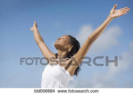 Picture - Hispanic woman with arms raised. Fotosearch