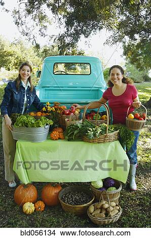 Picture - Hispanic women at organic farm stand. Fotosearch