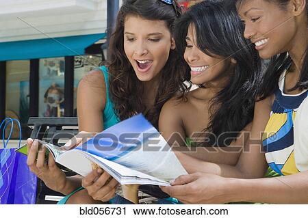 Hispanic women looking at magazine View Large Photo Image Stock Image - Hispanic women looking at magazine. Fotosearch