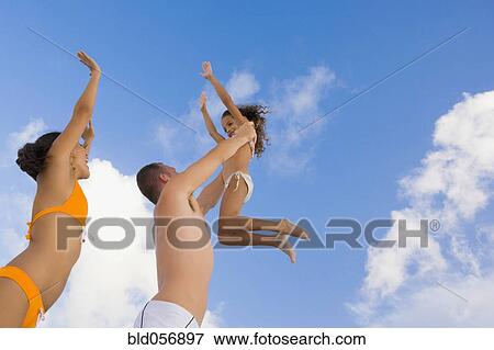 Mixed Race family in bathing suits playing View Large Photo Image Stock Photo - Mixed Race family in bathing suits playing. Fotosearch