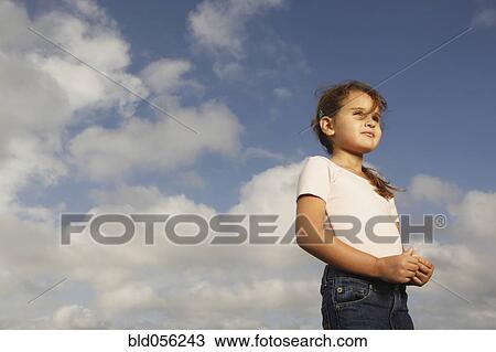 Stock Image - Mixed Race girl under blue sky. Fotosearch