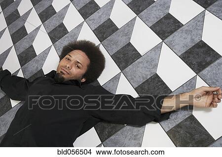 Mixed Race man laying on floor View Large Photo Image Picture - Mixed Race man laying on floor. Fotosearch