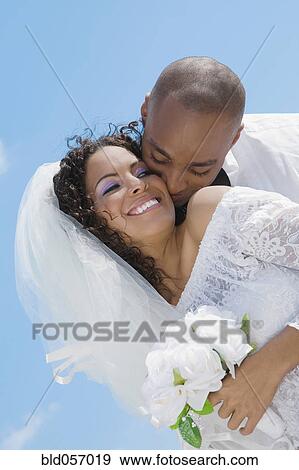 Multi-ethnic bride and groom hugging View Large Photo Image Stock Photo - Multi-ethnic bride and groom hugging. Fotosearch