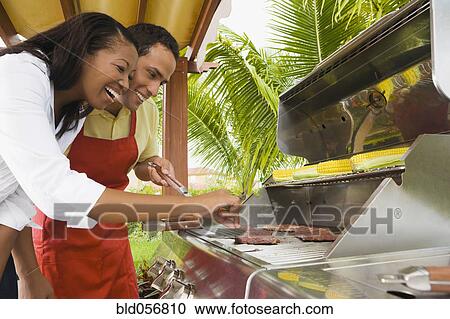 Stock Image - Multi-ethnic couple barbecuing. Fotosearch