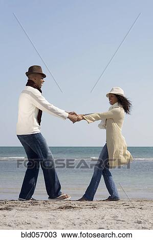 Stock Image - Multi-ethnic couple dancing at beach. Fotosearch