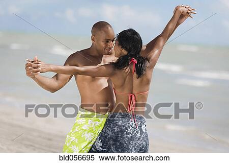 Stock Photography - Multi-ethnic couple dancing at beach. Fotosearch