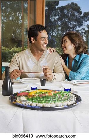Stock Photo - Multi-ethnic couple eating sushi. Fotosearch