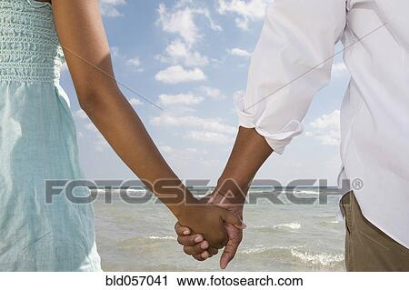 Stock Image - Multi-ethnic couple holding hands. Fotosearch