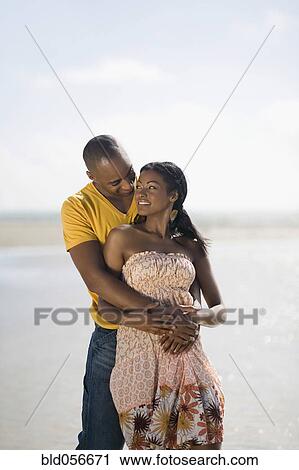 Multi-ethnic couple hugging at beach View Large Photo Image Stock Image - Multi-ethnic couple hugging at beach. Fotosearch