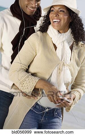 Multi-ethnic couple listening to mp3 same player View Large Photo Image Stock Photo - Multi-ethnic couple listening to mp3 same player. Fotosearch