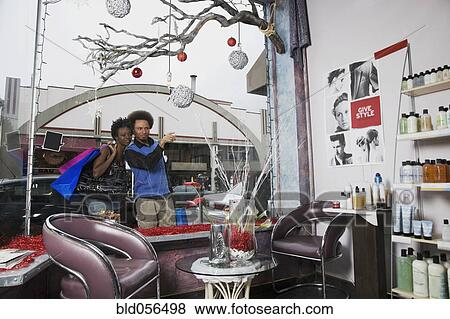 Stock Photo - Multi-ethnic couple looking in salon window. Fotosearch