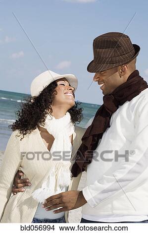 Picture - Multi-ethnic couple smiling at each other. Fotosearch