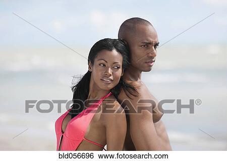 Multi-ethnic couple standing back to back View Large Photo Image Stock Photograph - Multi-ethnic couple standing back to back. Fotosearch