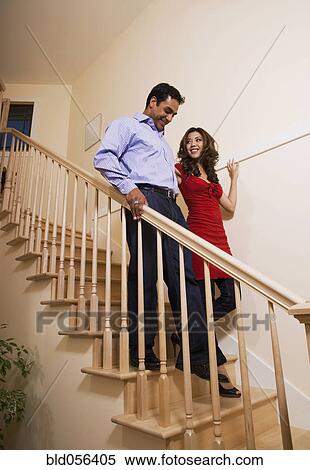 Stock Photography - Multi-ethnic couple walking down stairs. Fotosearch