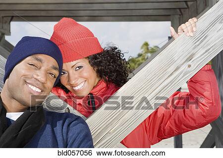 Multi-ethnic couple wearing winter clothing View Large Photo Image Stock Photograph - Multi-ethnic couple wearing winter clothing. Fotosearch