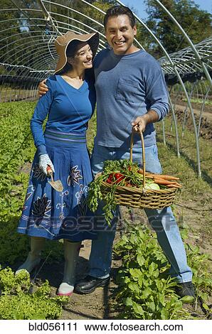 Stock Image - Multi-ethnic couple with basket of organic produce. Fotosearch