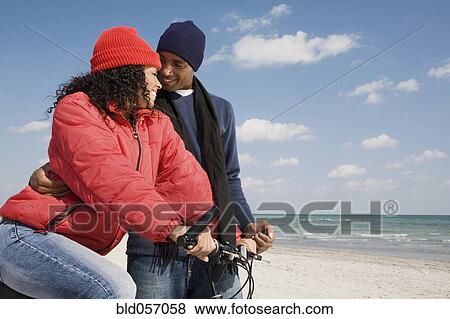 Multi-ethnic couple with bicycle at beach View Large Photo Image Stock Photo - Multi-ethnic couple with bicycle at beach. Fotosearch